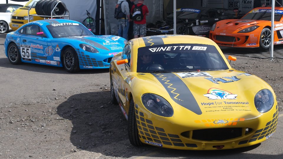 The Ginetta G40, as used in the Ginetta Juniors championship. It looks very much like a grand touring car, closed cockpit and all. Photo taken unaltered from Wikimedia commons, taken by user Paul ss1 and released under CC-BY-SA 3.0: https://creativecommons.org/licenses/by-sa/3.0/