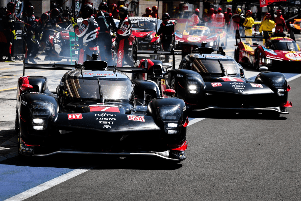 Toyota's #7 and #8 Hypercars peel out of the pits during testing in Qatar, with the Ferrari #51 and #50 plus an indeterminate GT3 car in the background. (image credit: Toyota Gazoo Racing)